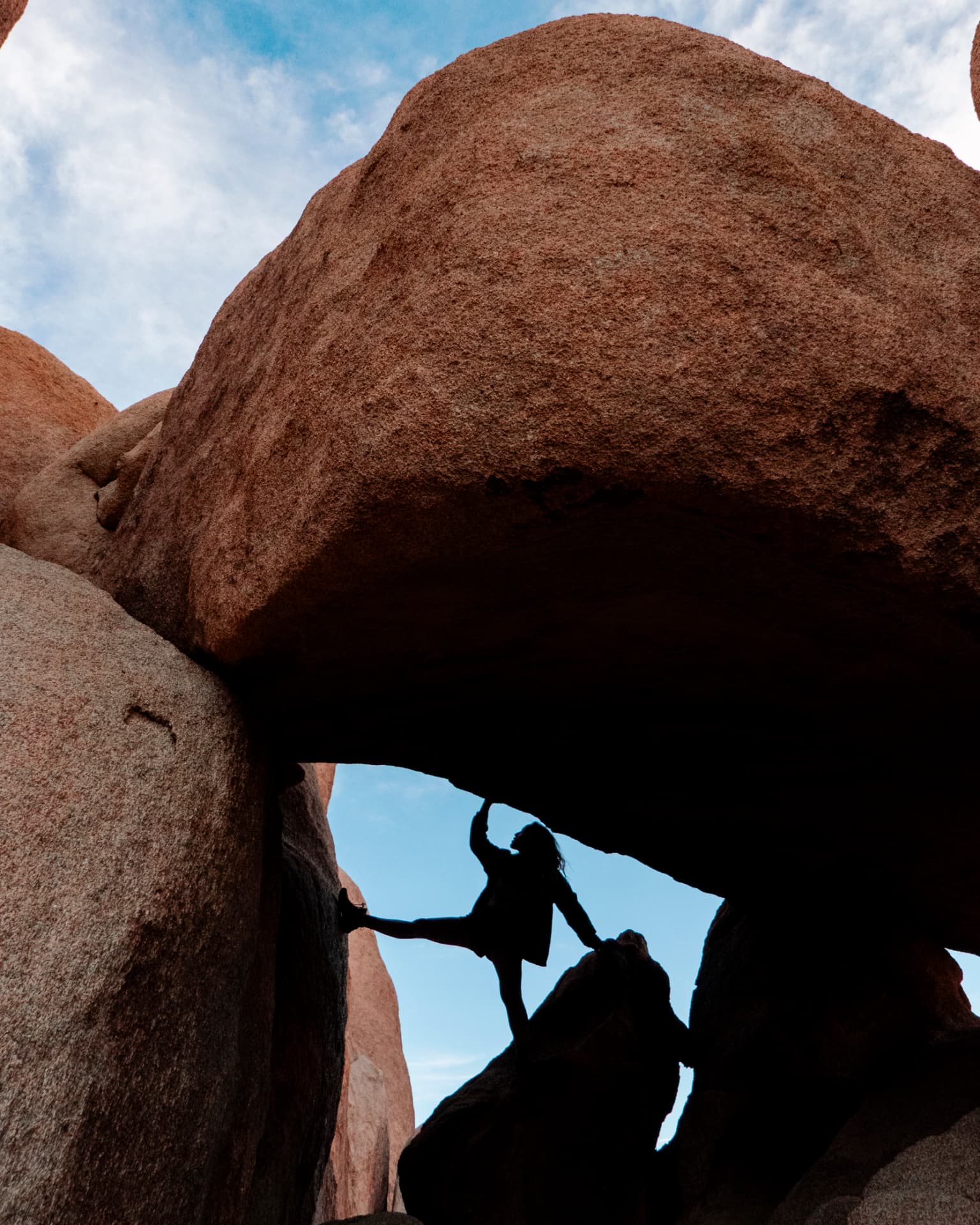 Woman framed beneath a desert rock arch